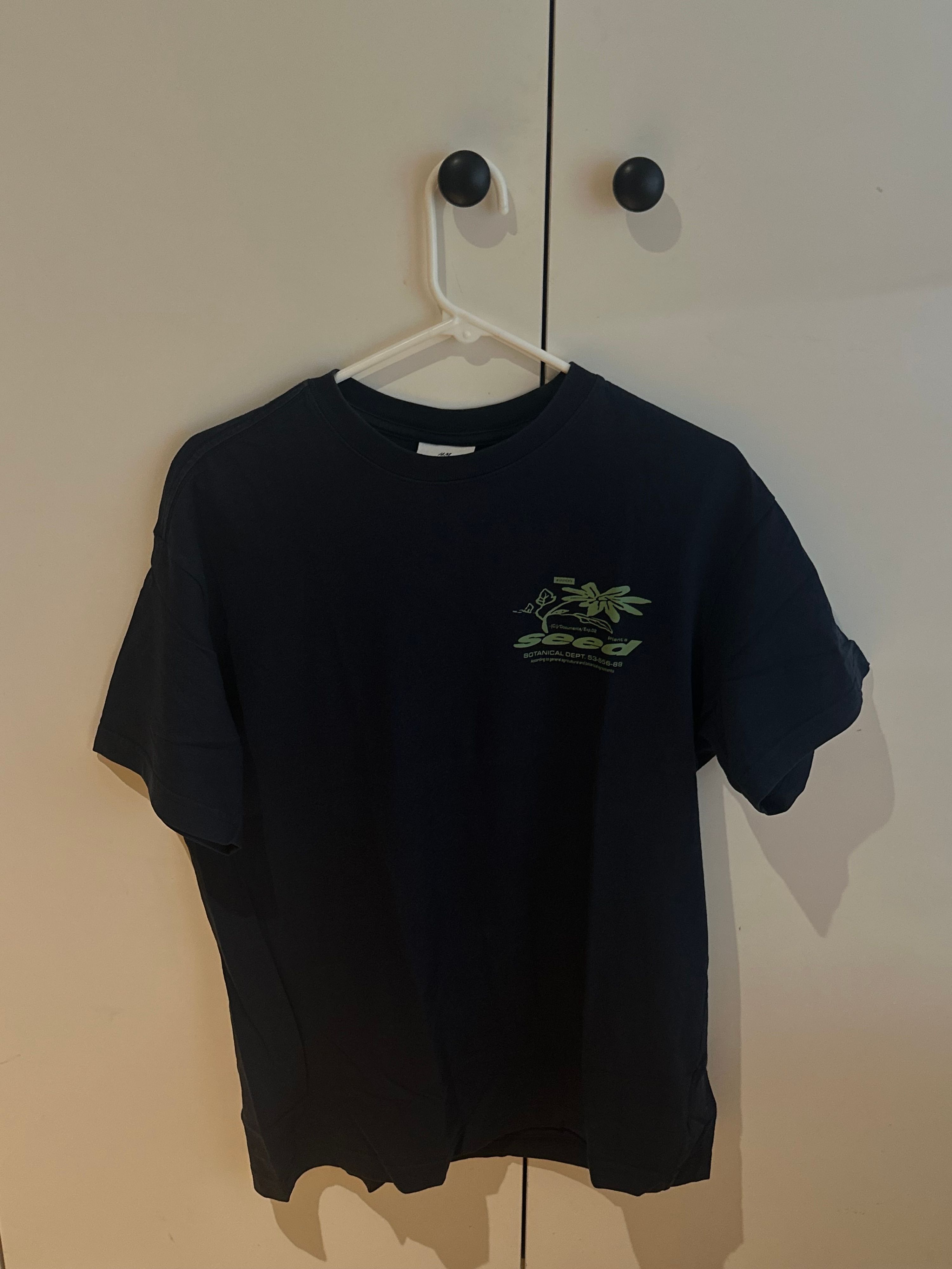 חולצת טי כחולה נייבי של H&M עם הדפס גרפי ירוק