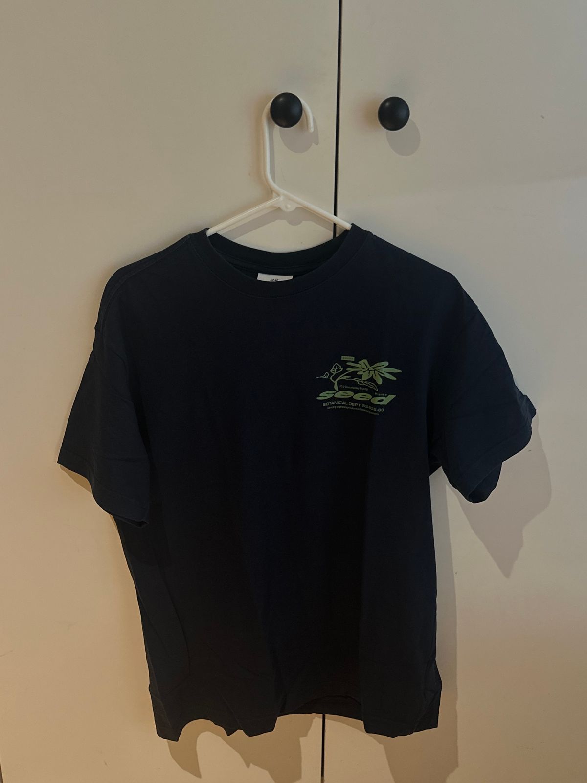 חולצת טי כחולה נייבי של H&M עם הדפס גרפי ירוק